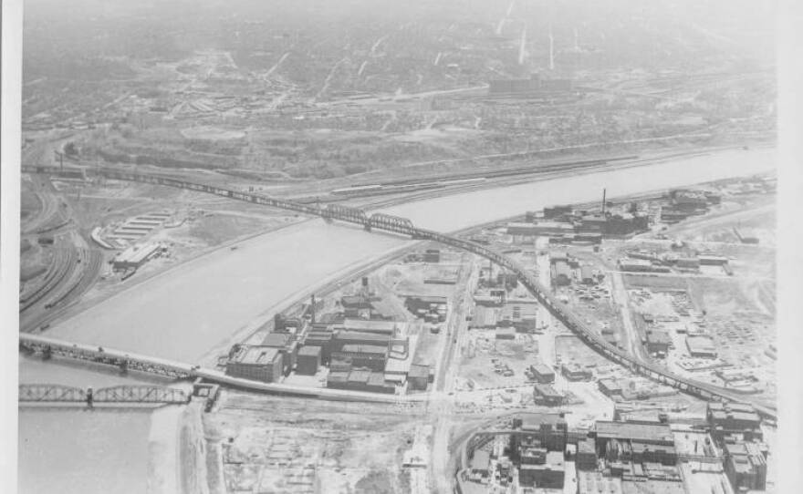 Archival aerial black and white photo of a river with rail bridges over it.