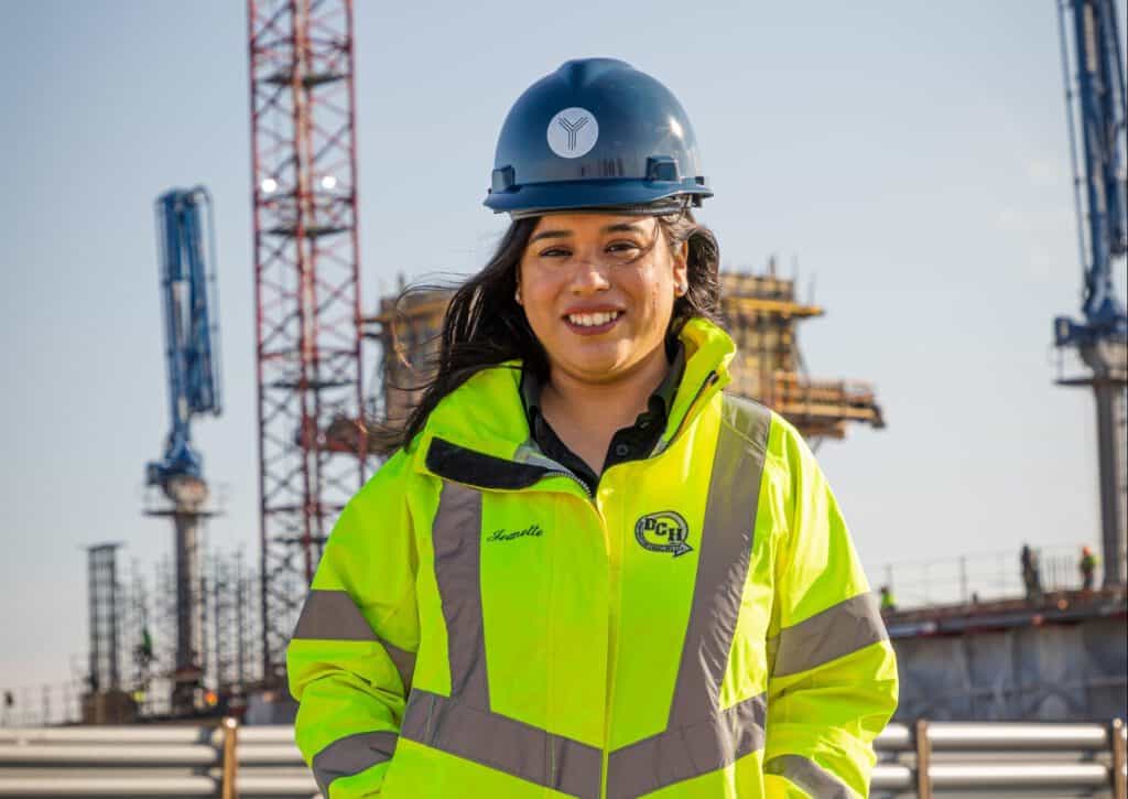 Female construction engineer in safety gear at a construction site.