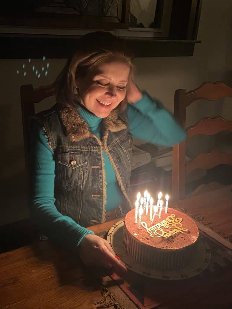 Woman celebrating birthday with a cake, symbolizing hope and life renewal through organ donation.