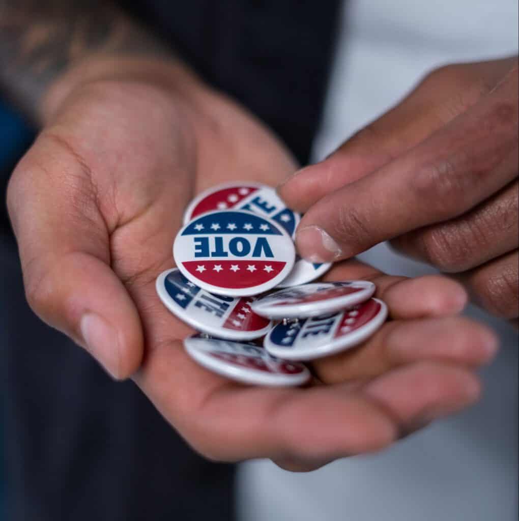 Vote campaign buttons in hand, emphasizing the importance of messaging to reach Latino voters effect.