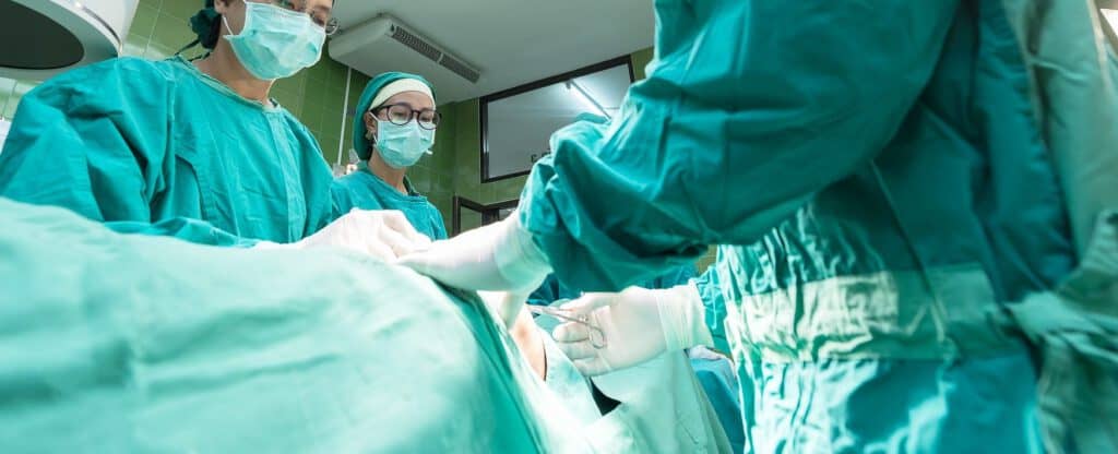 A healthy team of surgeons performing an organ transplant surgery in an operating room.