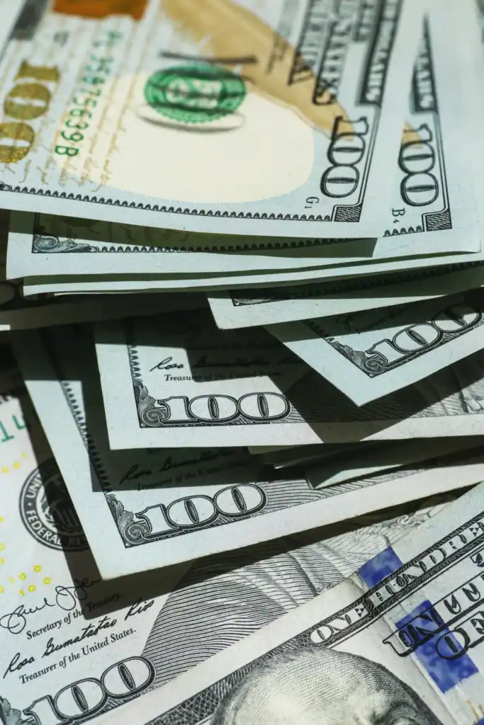 Stacks of hundred-dollar bills highlighting economic disparities faced by Latinos.