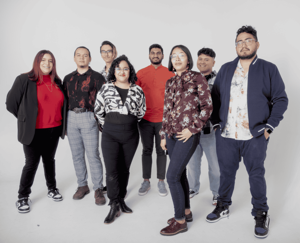 Diverse group of young professionals posing for a photo in a studio.