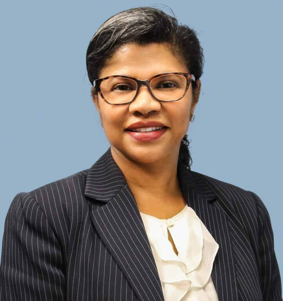 Ingrid Canady, Latino News Network expert, wearing glasses and a professional pinstripe suit, smilin.