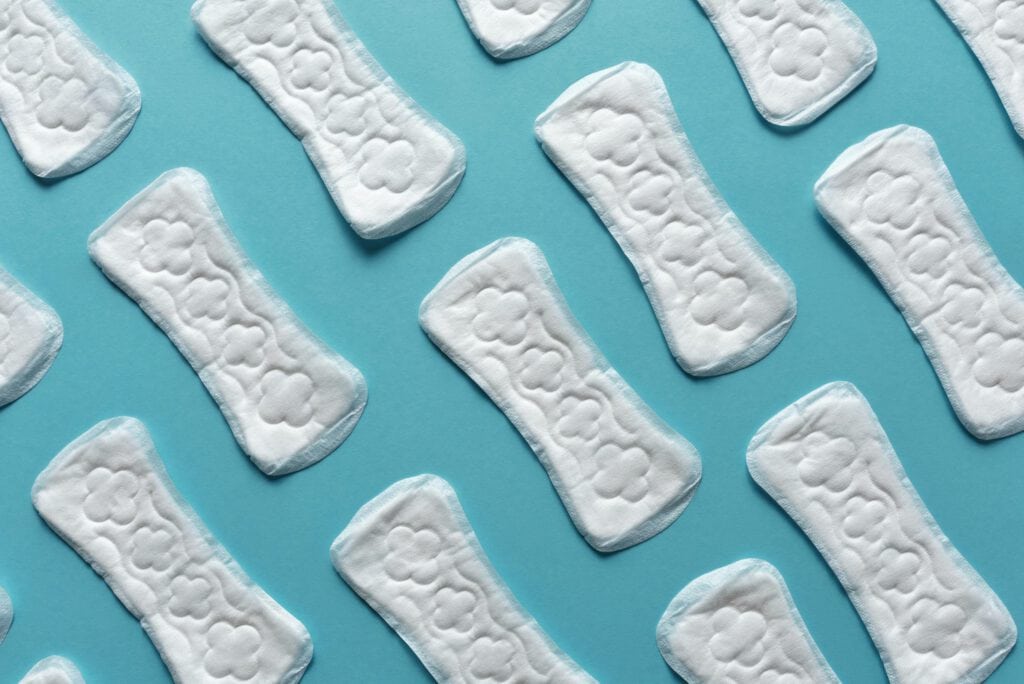 Pads arranged on a blue background, highlighting menstrual health and hygiene issues.