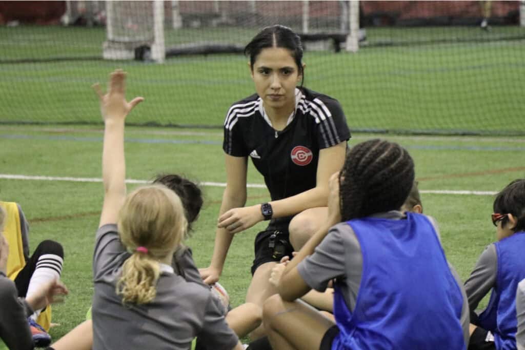 Youth soccer coach Christina Murillo motivates children during a training session.