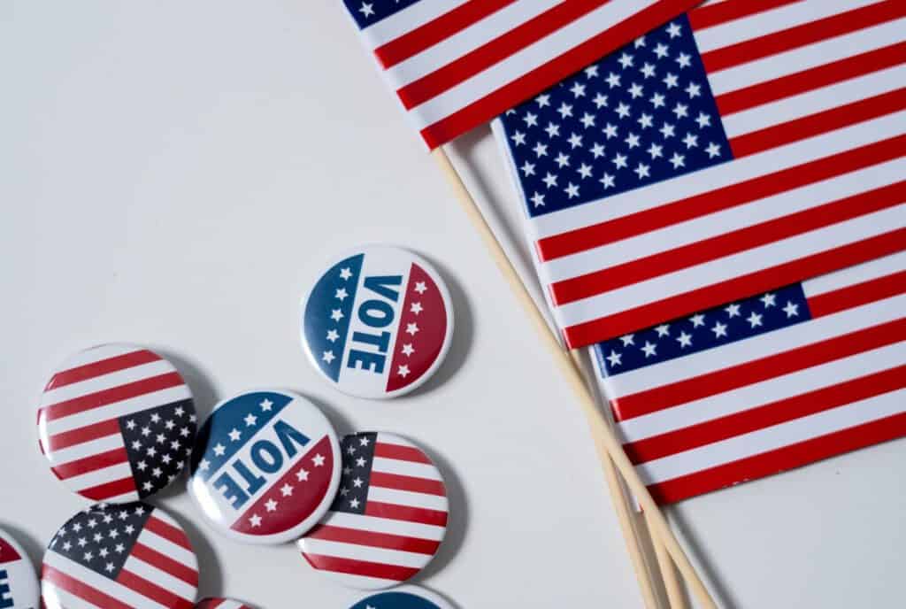 Vote buttons and American flags for election awareness and civic participation.