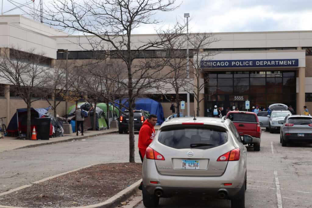 Migrants seeking assistance outside Chicago Police Department building.
