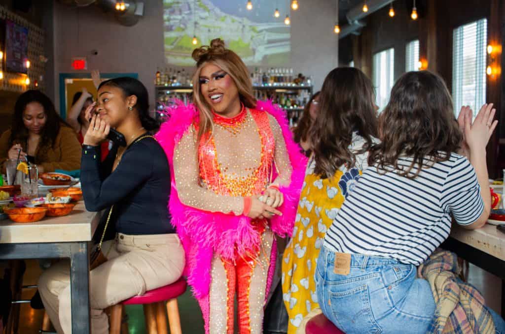 Latino drag performer in vibrant pink costume at Boston’s Latine Drag Community event.