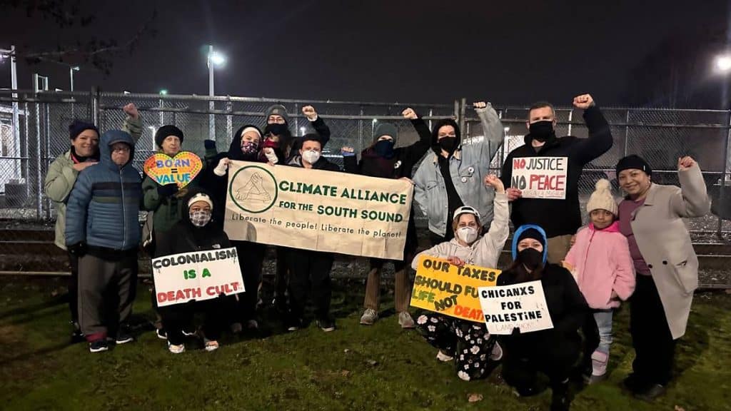 Protesters hold signs demanding justice and climate action outside NW Detention Center. Over 100 det.