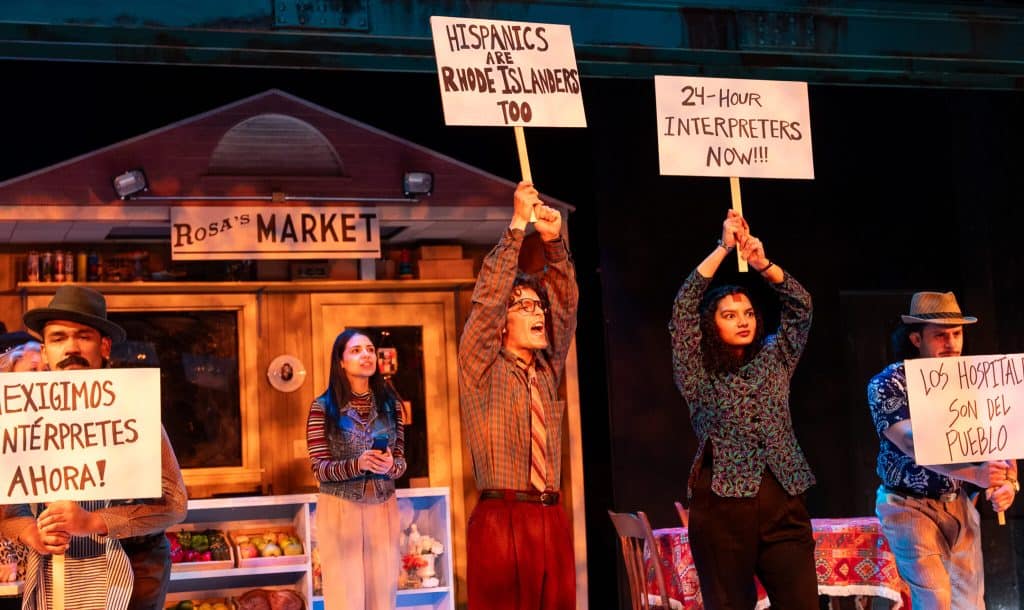 Protesters holding signs advocating for Hispanic and Rhode Islander rights during a demonstration.