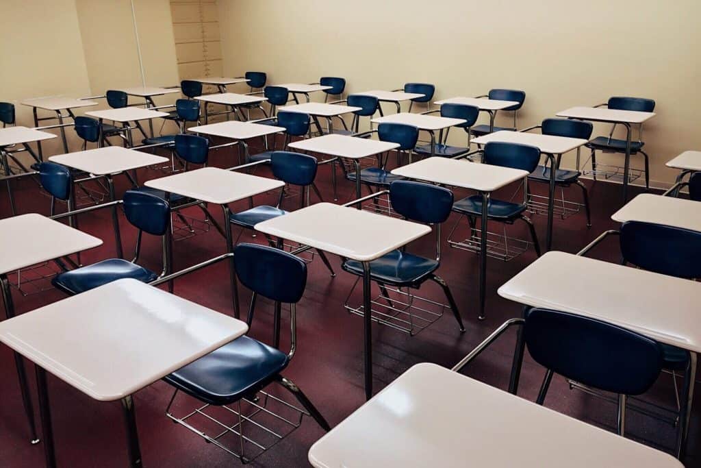 Empty classroom with desks and chairs, ready for students.