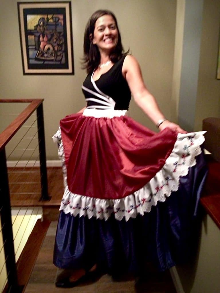 Venezuelan woman in traditional dress celebrating Hispanic culture at an indoor event.
