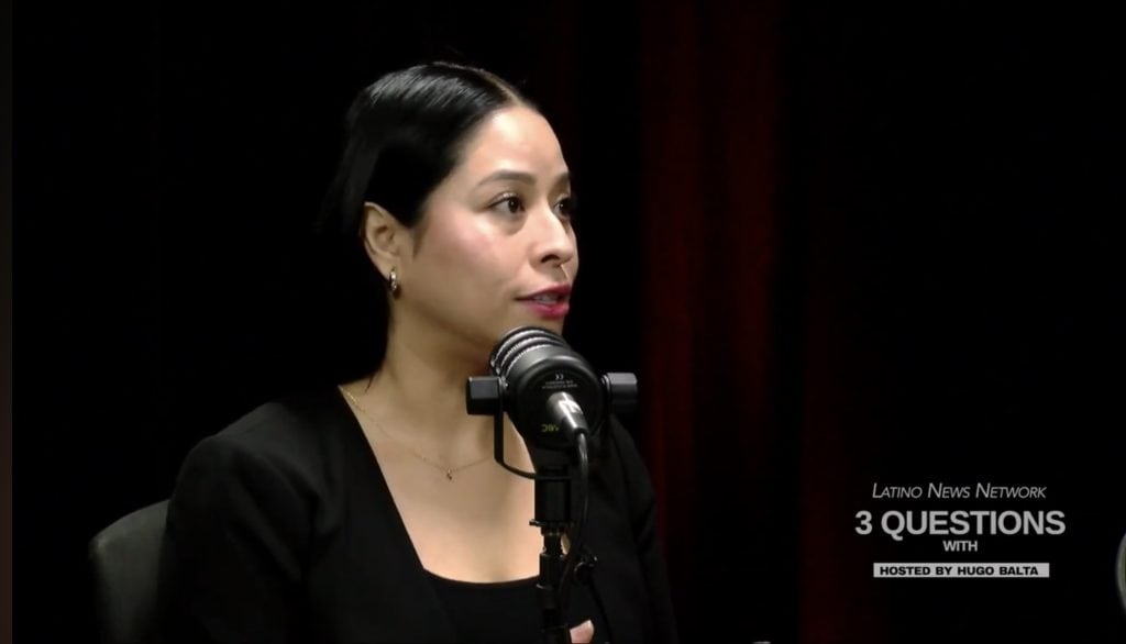 Empowered Latina woman speaking at a panel discussion on leadership and lived experience.
