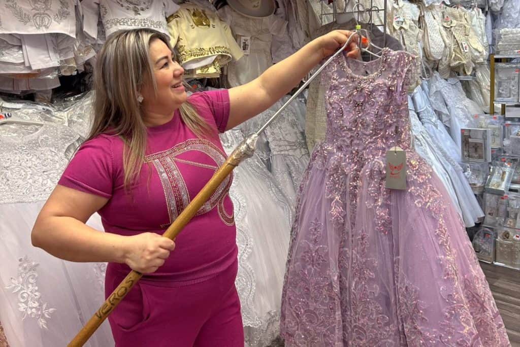 Latino woman shopping for a pink lace dress at Little Village Discount Mall.