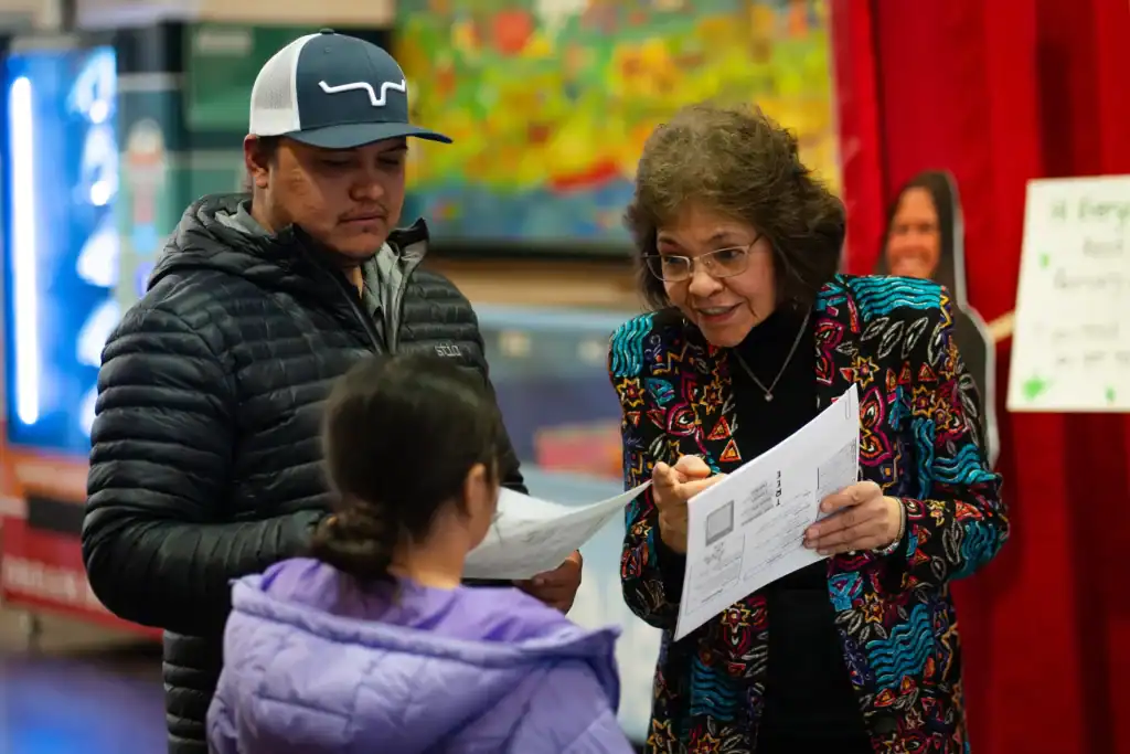 Latino interpreter assisting Latino families with educational investment guidance.