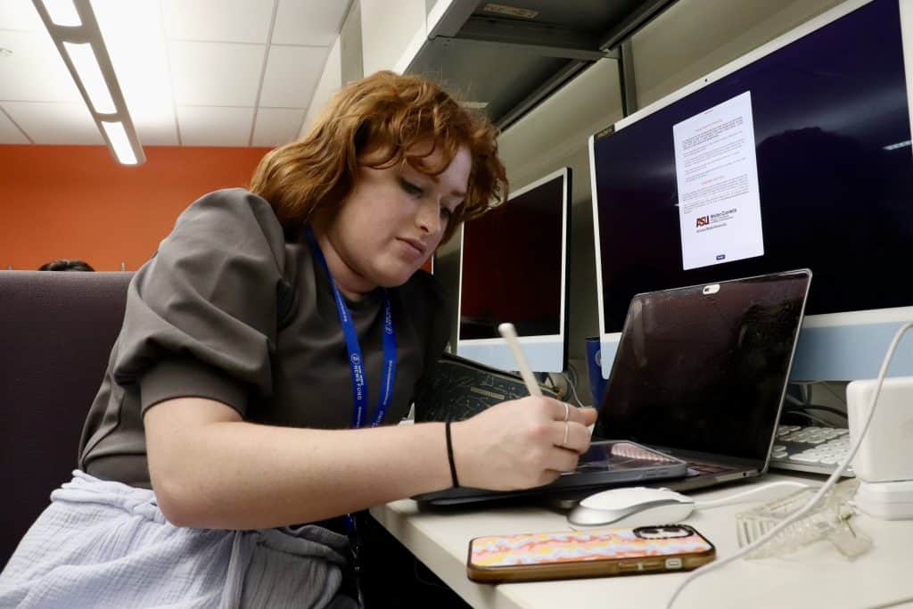 Intern working on a laptop at a computer station during the summer internship program.