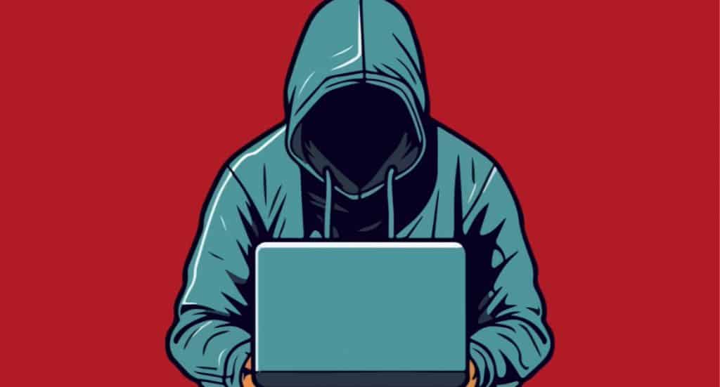 Hooded hacker working on laptop, symbolizing cyber fraud prevention and recovery.