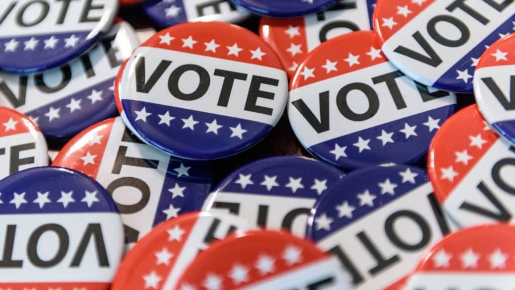 Accessible voting buttons with "VOTE" text in red, white, and blue colors for Spanish-speaking voter.