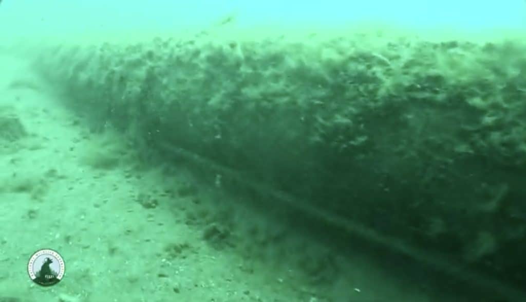 Underwater view of a submerged tunnel structure near the seabed.