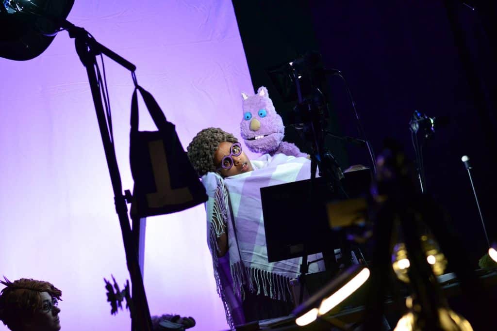 Puppeteer with puppet performing on stage during a theatrical show in Minnesota.