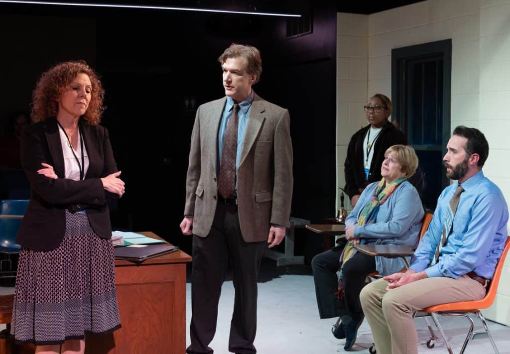 Theatre discussion on political dialogue with diverse participants in a staged setting.