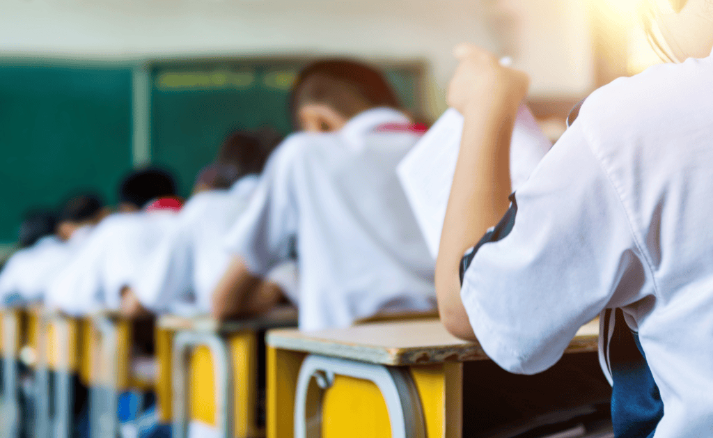Students in a classroom with desks, focusing on immigration issues affecting schools.