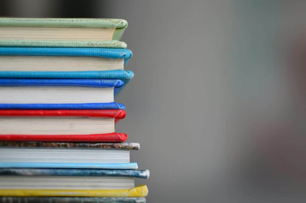Stack of colorful books representing education and learning opportunities for Latinos.