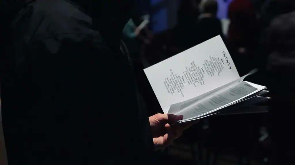 Person holding a booklet at a rally, emphasizing religious freedom for progressives.