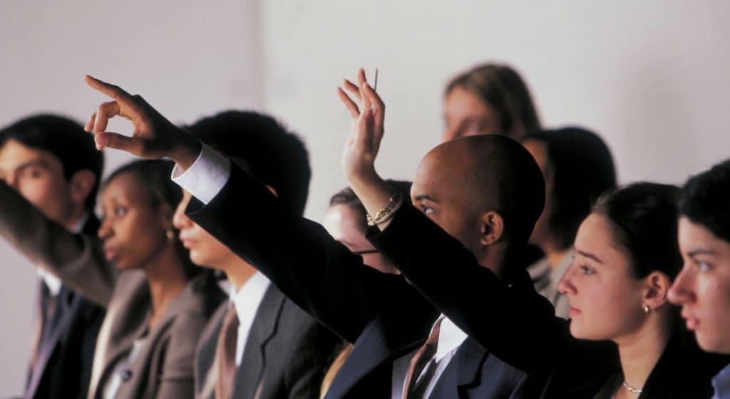 Empowered diverse activists raising hands at a press conference for free speech and activism.