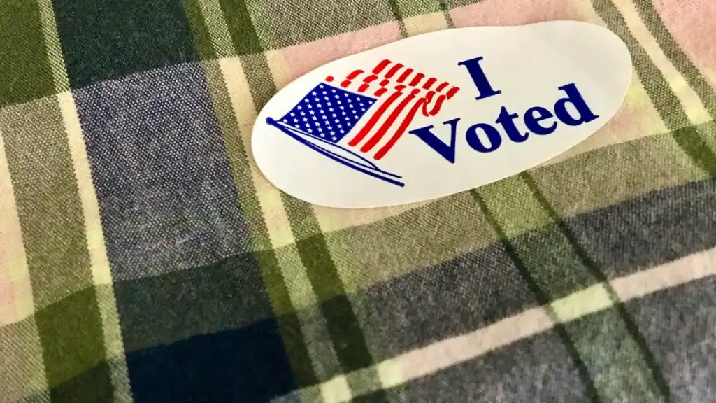 "I Voted" sticker featuring American flag, symbolizing civic participation.