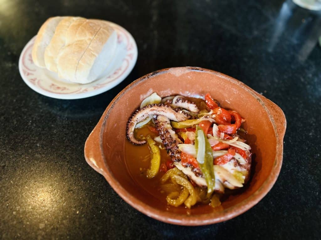Aguardente served with bread in a traditional clay bowl, highlighting Rhode Island's unique culinary.