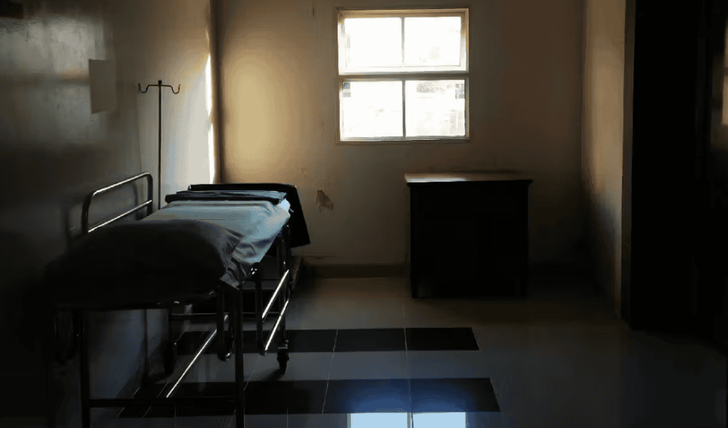 A quiet, empty maternity ward room with a single bed and minimal furnishings.