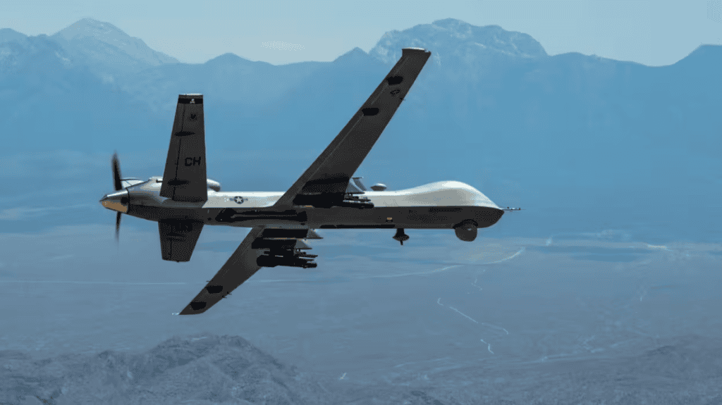 MQ-9 Predator drone flying over mountainous terrain at the border.