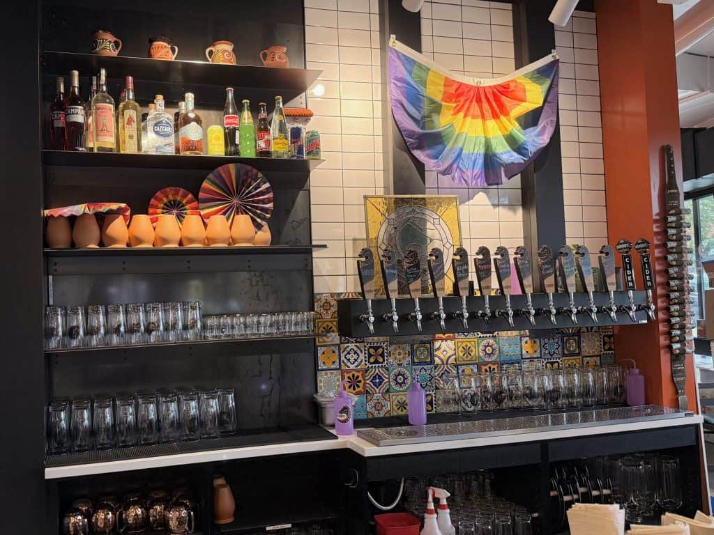 A colorful bar display with tequila bottles, traditional Mexican pottery, and vibrant decorations in.