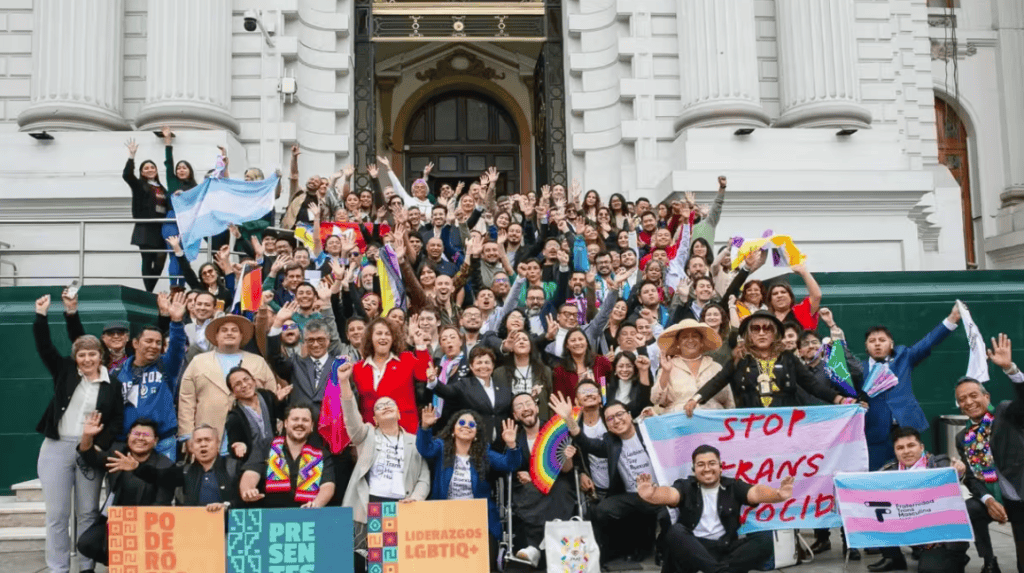 Protesters rallying for LGBTQ+ rights outside a historic government building.