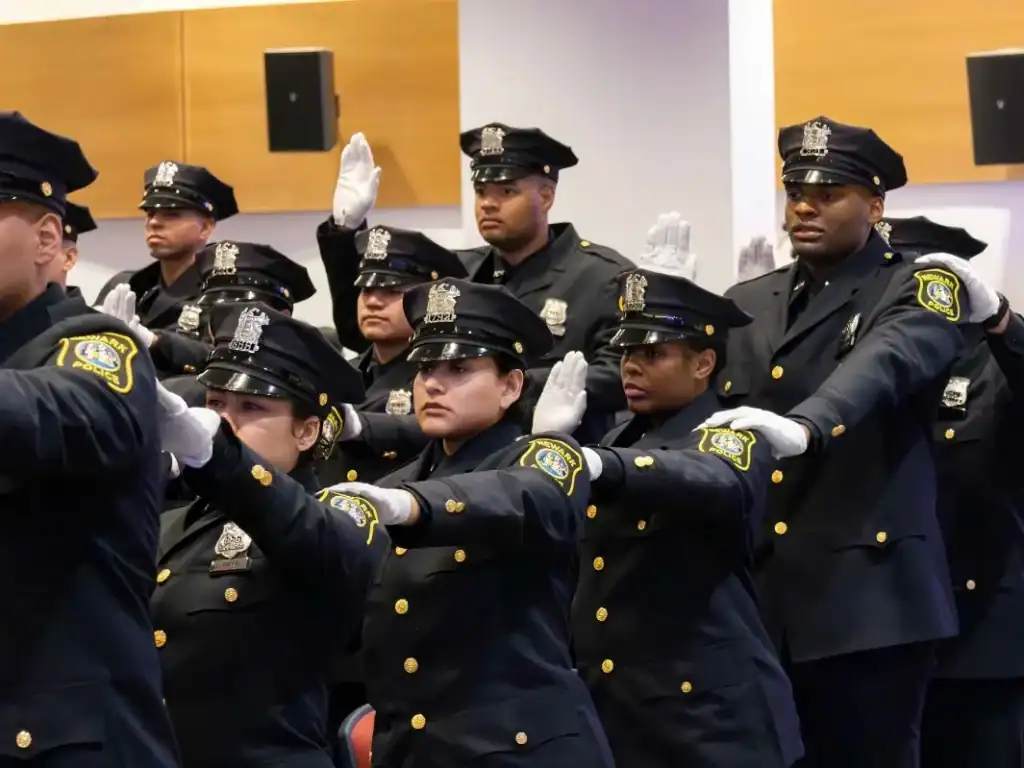Newark police cadets of diverse backgrounds during graduation ceremony.