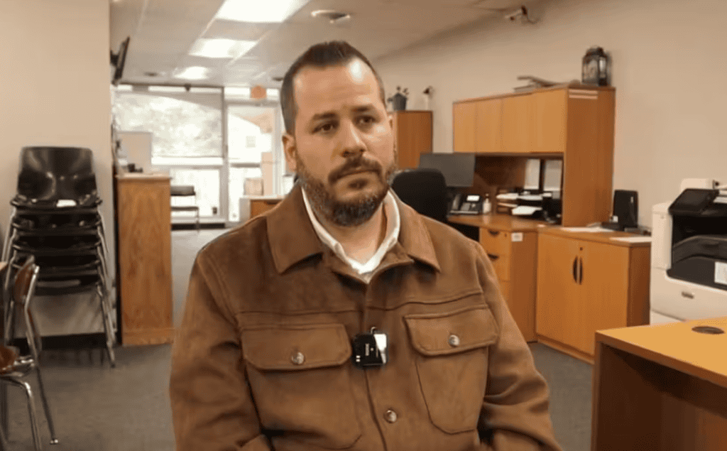 Gabriel Rodríguez speaking in an office setting, advocating for immigrant community support and empo.