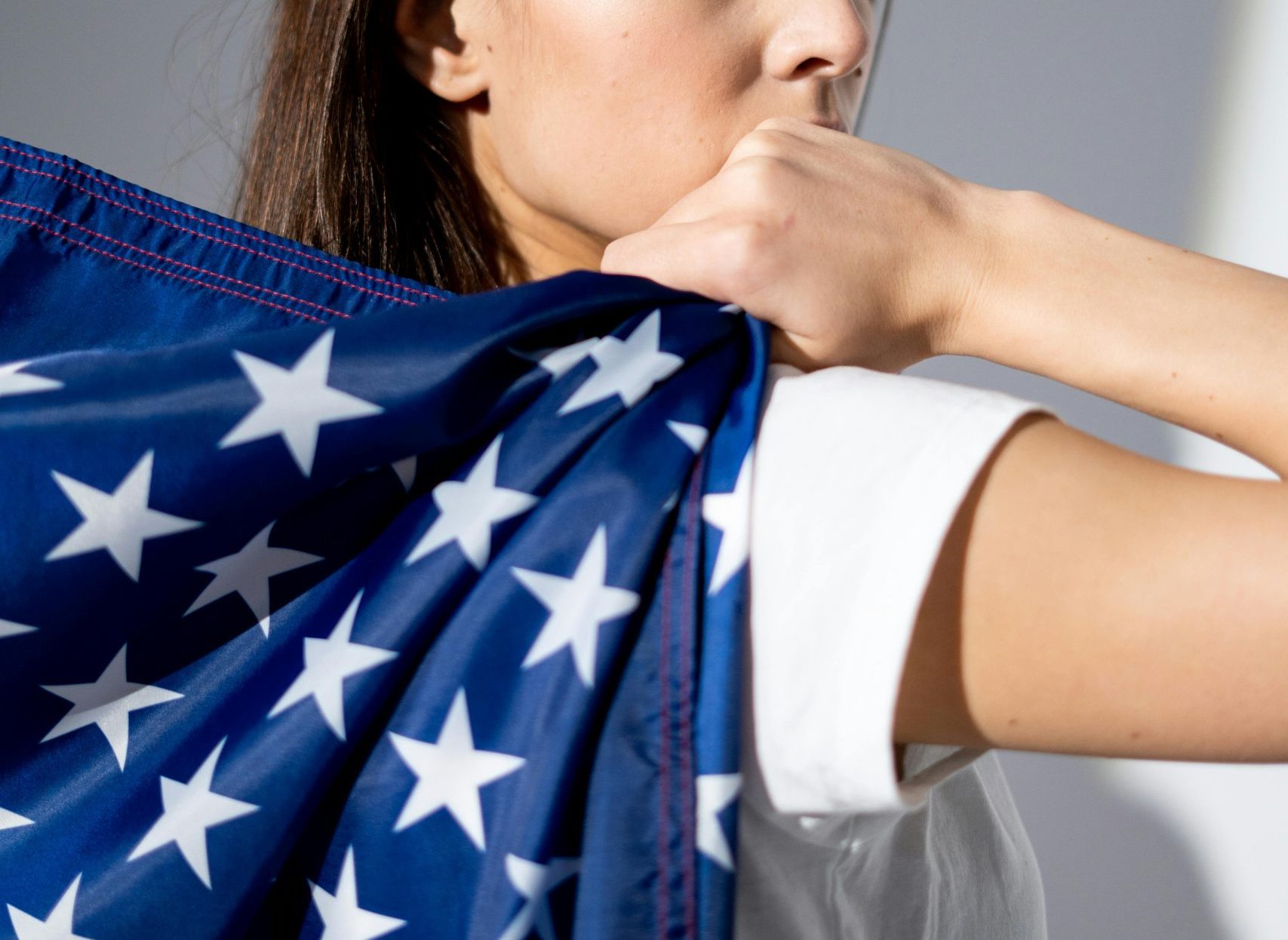 A patriotic woman poses with the American flag, symbolizing national pride.