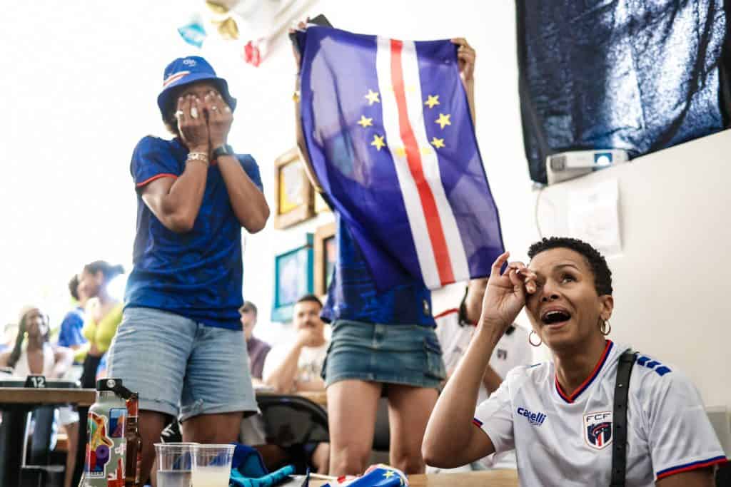 Fans celebrating and reacting to a World Cup game at a watch party.