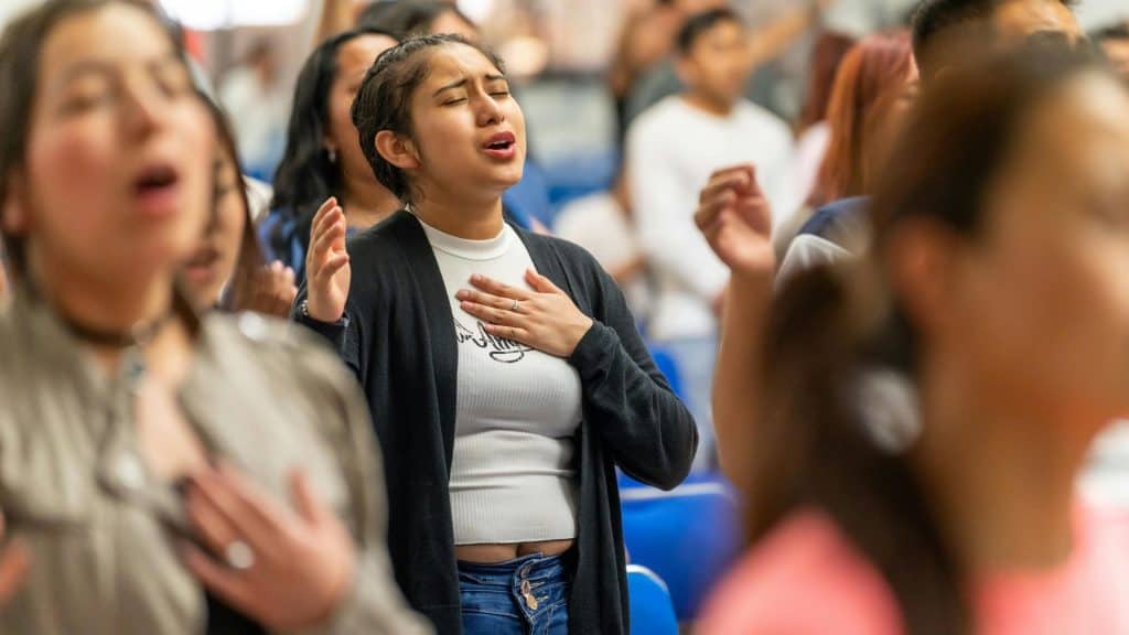 Latino individuals participating in a community prayer or gathering.