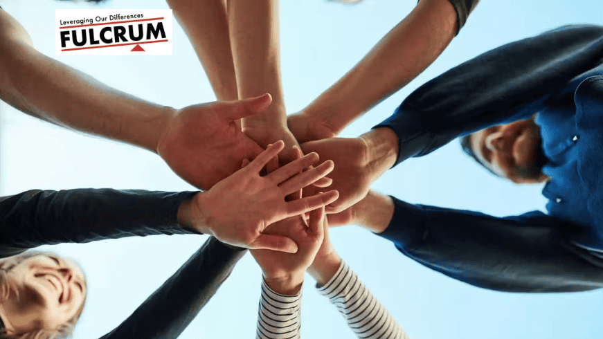 Team of diverse workers joining hands in unity for workers' rights.