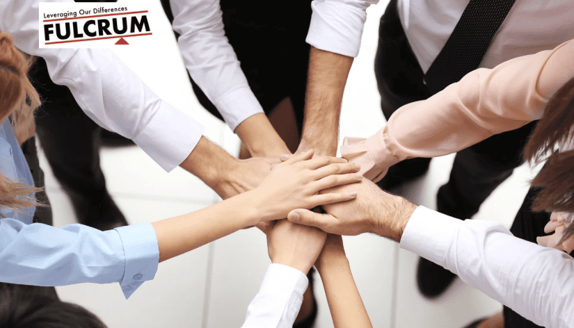 Diverse team members placing hands together in unity for teamwork and collaboration.