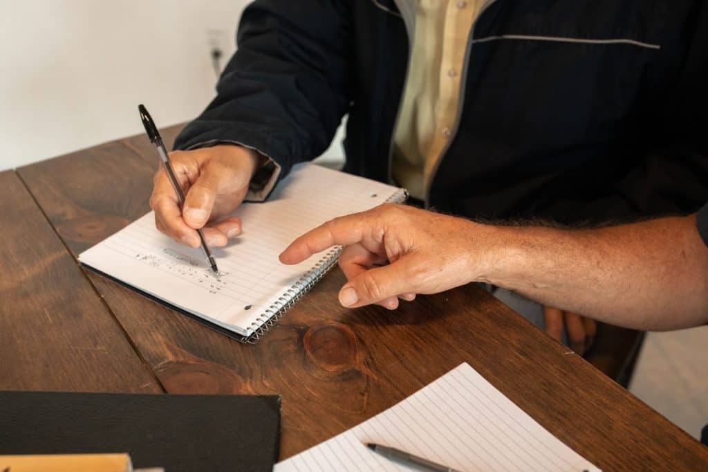 Two people discussing and taking notes during a business meeting.