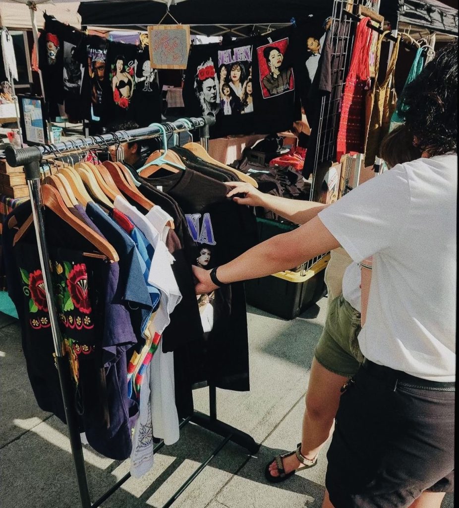 Colorful clothing and artwork display at CALN community market.
