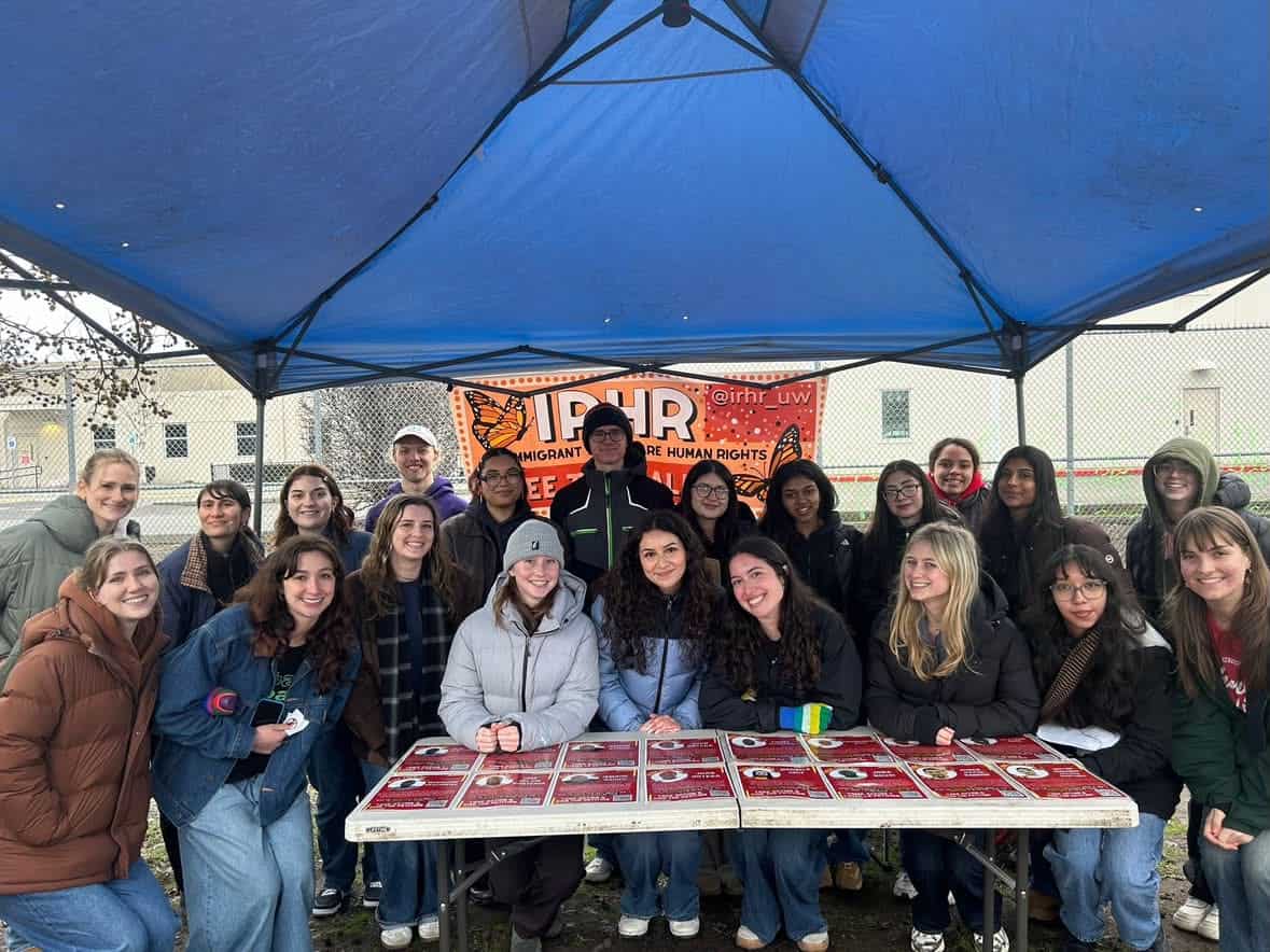 Students gather at a rally advocating for detained immigrants under a blue canopy.